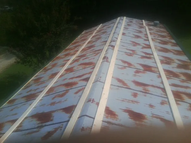 Rusted metal roof panels with new wood purlins before replacement — Storm Damage Roof Repair in Miamiville by Roofing Brothers