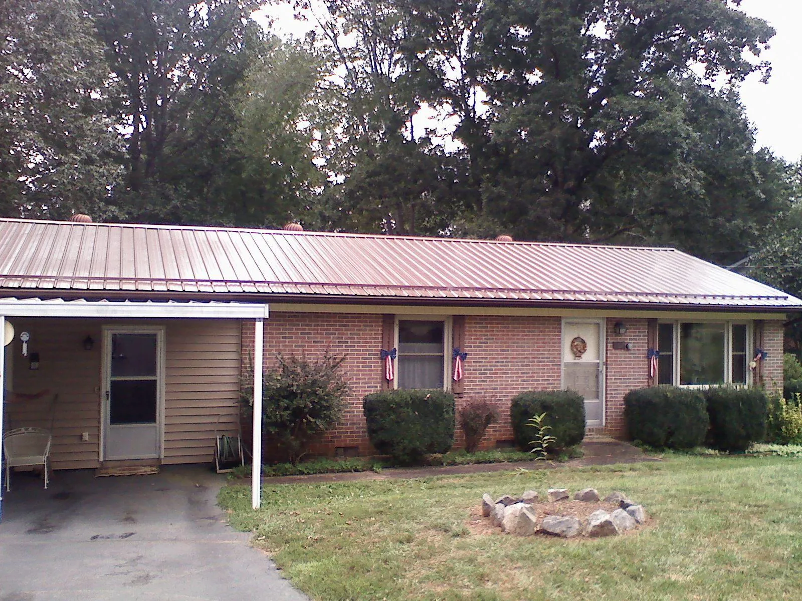 Bronze metal roof and carport on a brick ranch home — Roof Repair work by our crew in Miamiville